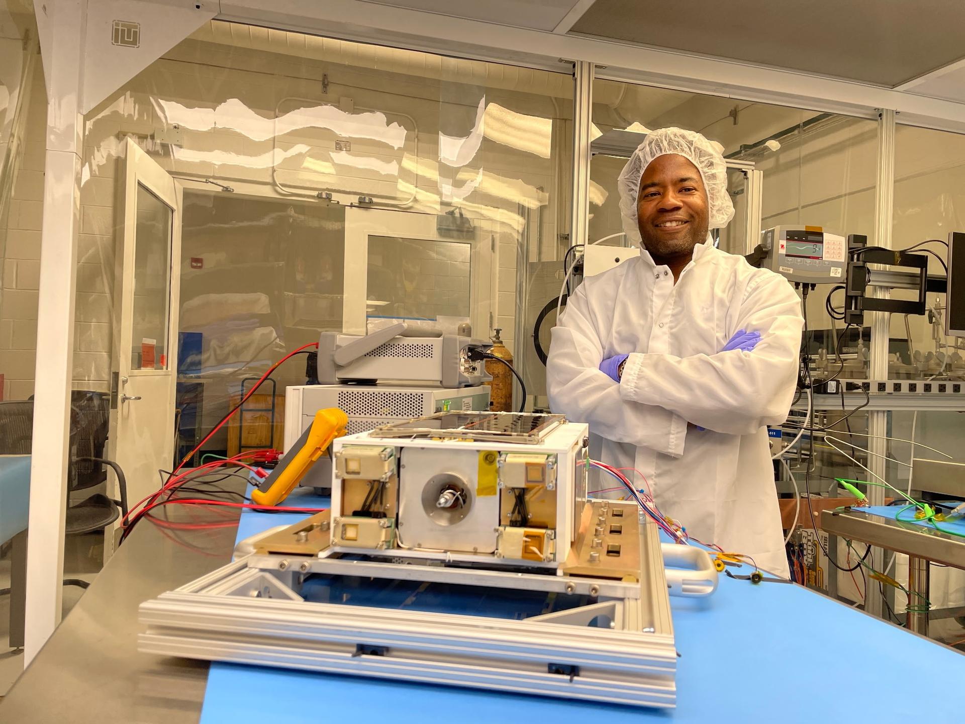 NASA project manager Nehemiah Williams beside ASCENT flight hardware in a Marshall clean room